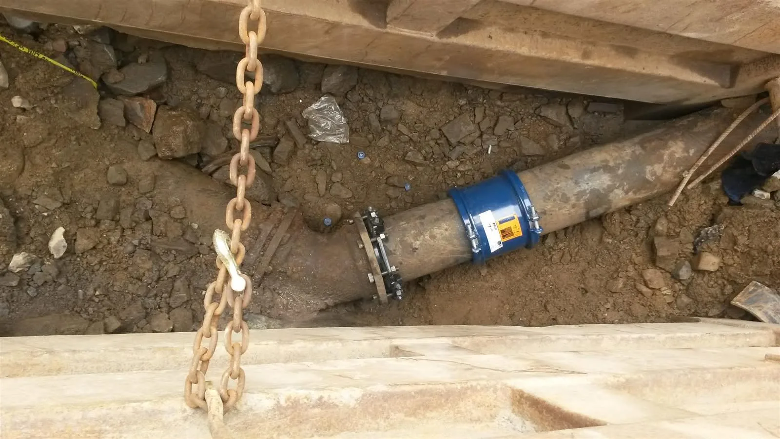 Sewer pipe coupling under a trench box