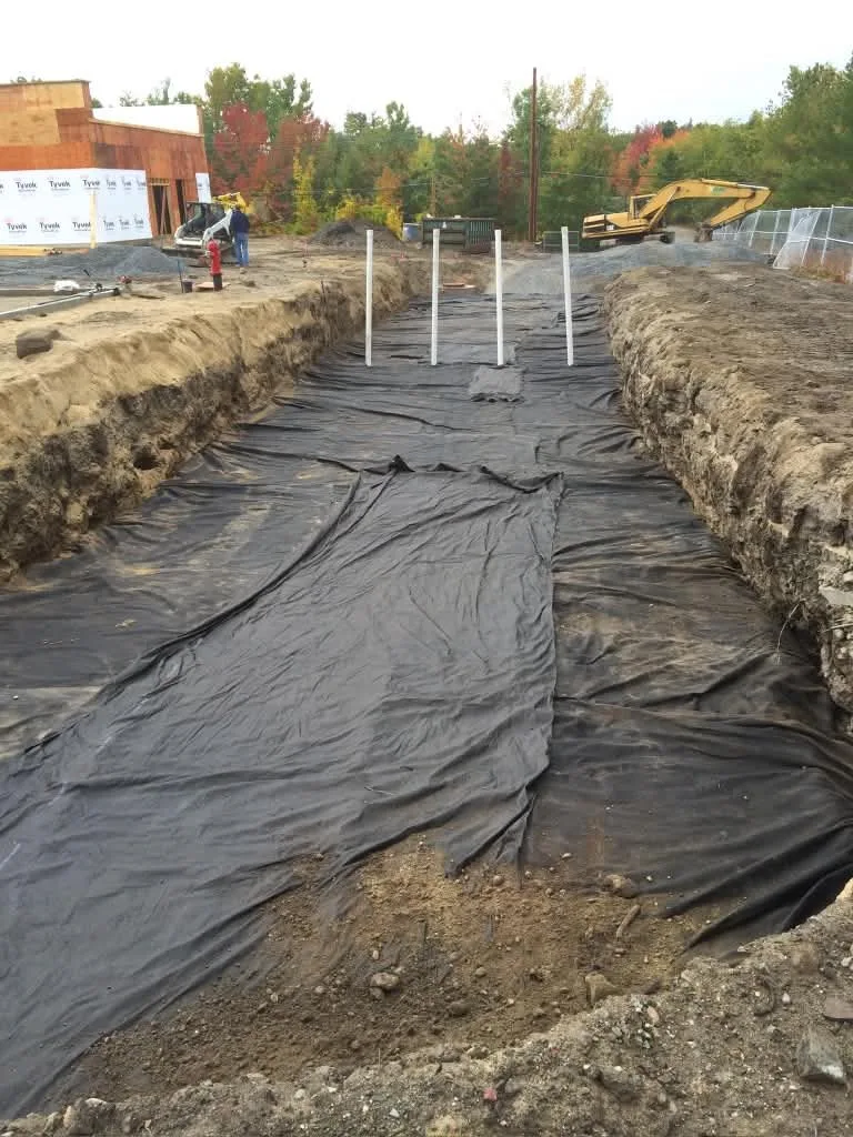 A drainage trench lined with filter fabric and riser pipes