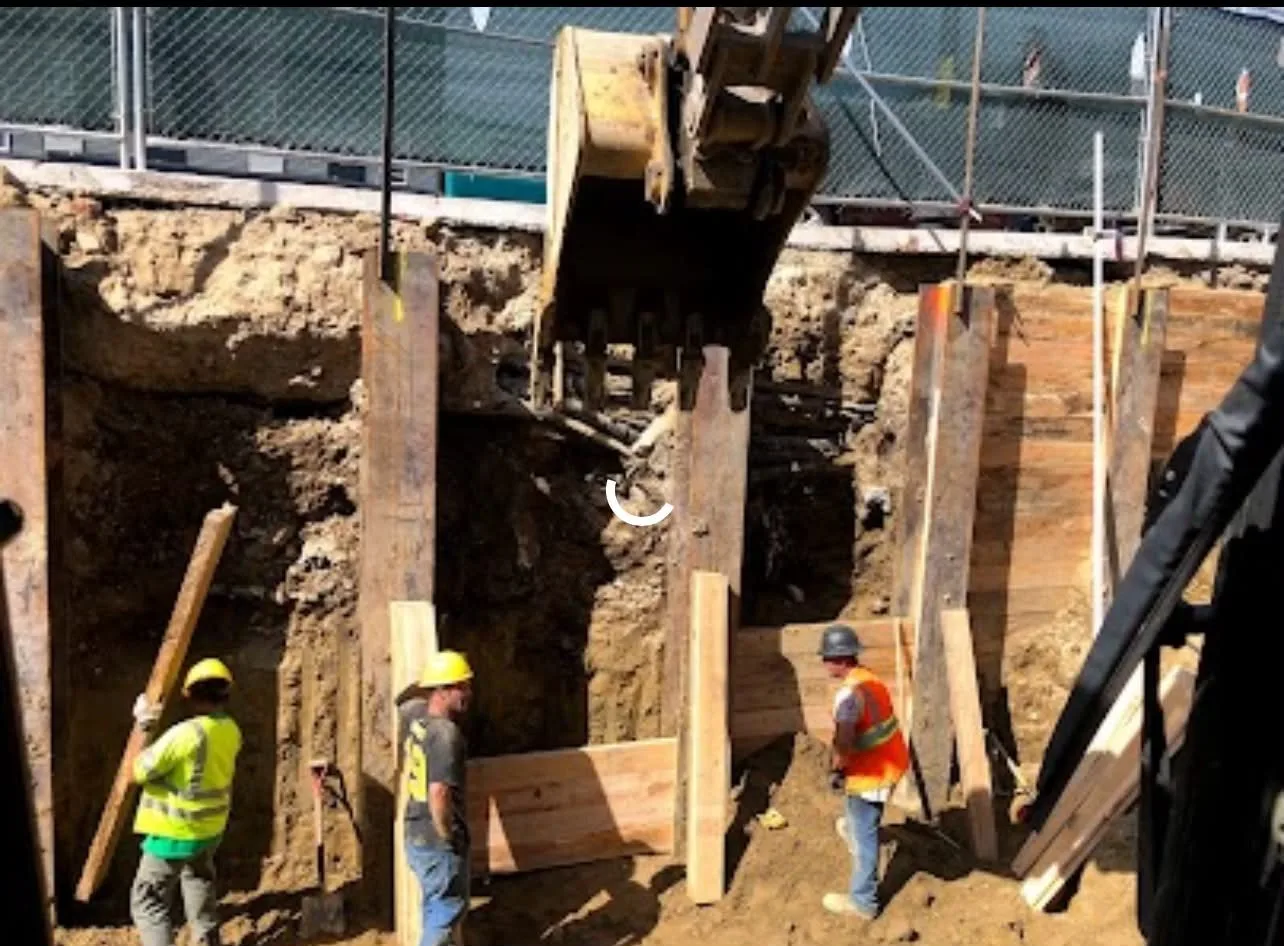 Crew working inside a timber-shored excavation